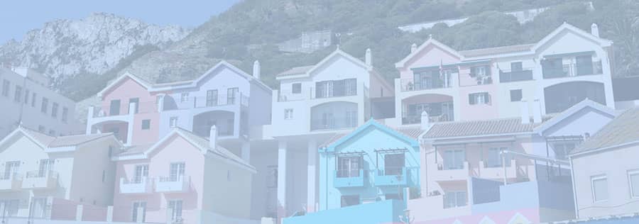 Pretty coloured houses and flats in Catalan bay, Gibraltar overlooking the sea with the rock as a backdrop.